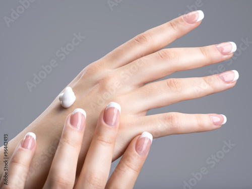 Close-up female hands apllying hand cream