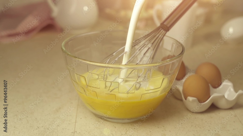 Chef pour milk onto whisked eggs Chef pour milk onto whisked eggs