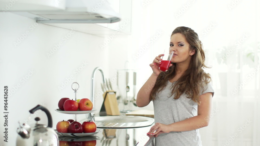 Young woman goes to table and drinking delicious juice Young woman goes to table and drinking delicious juice