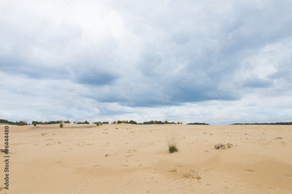 Cloudy blue sky above sand dunes
