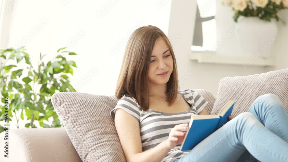 Young woman reading book and looking out the window Young woman reading book and looking out the window