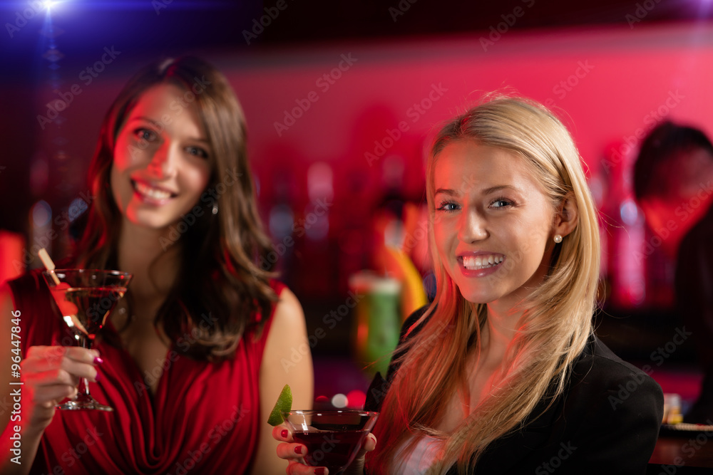 Two girls at the bar with cocktail drink