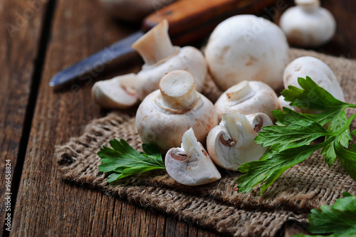 Raw champignon mushroom on wooden background