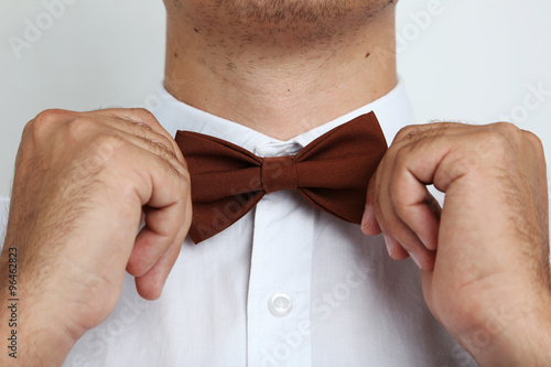 Man's hands touching bow-tie