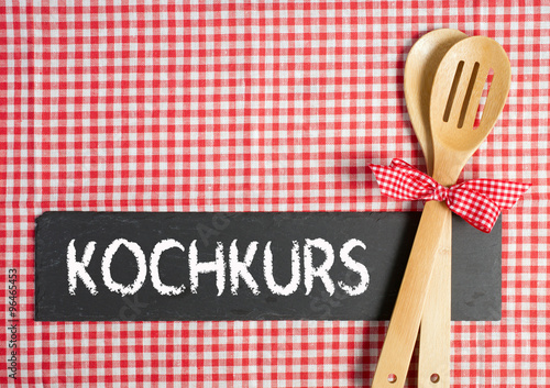 Kochkurs - Kochlöffel mit Schiefertafel und Text auf Tischtuch