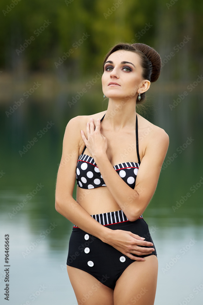 Young woman in a retro swimsuit posing outdoors Young woman in a retro swimsuit posing outdoors