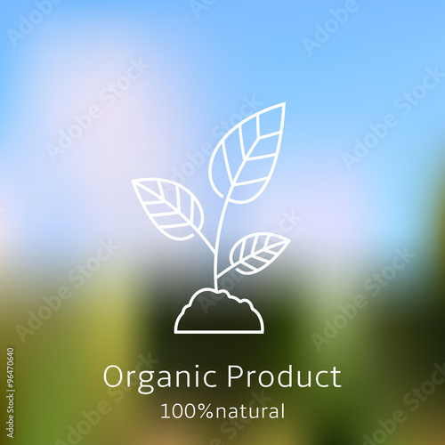 Organic product badge with sprout on blurred landscape