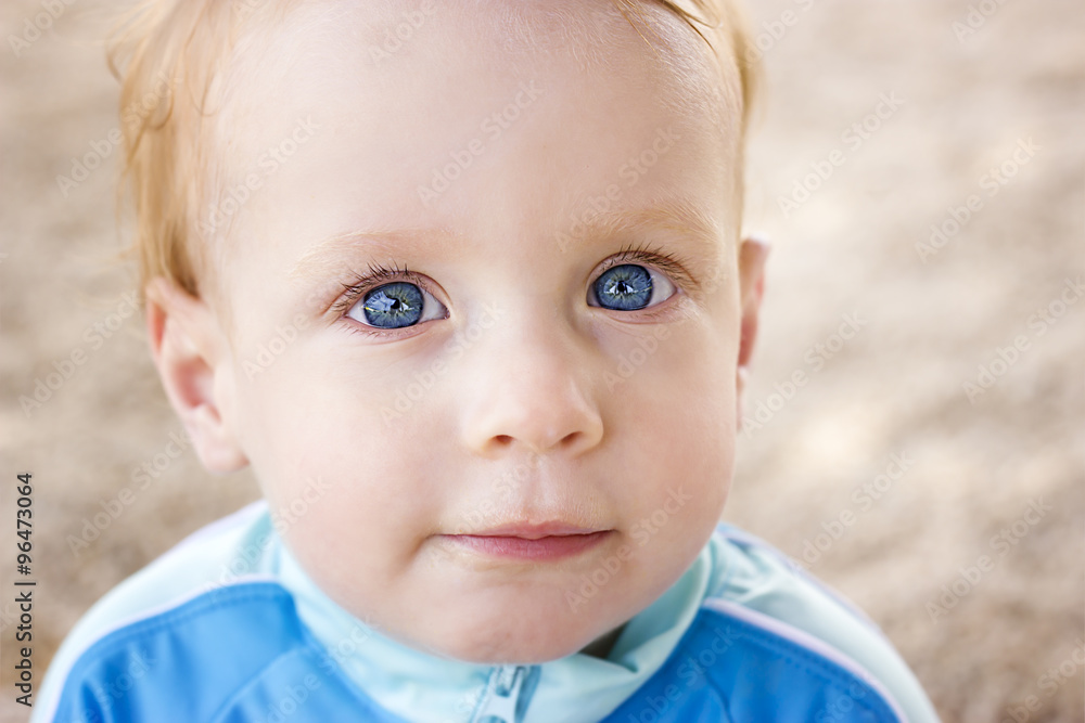Adorable little toddler boy sitting on the beach Adorable little toddler boy sitting on the beach