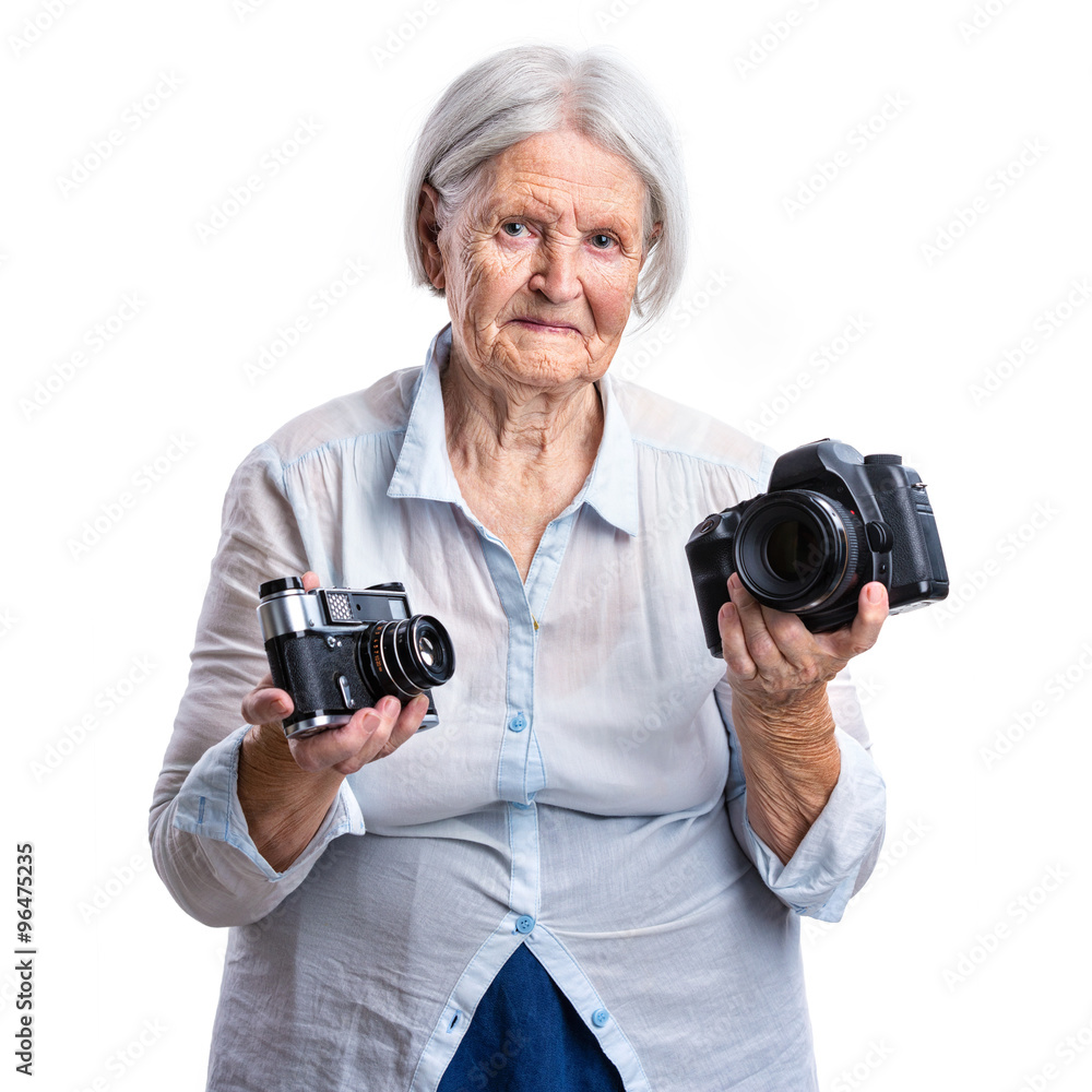 Senior woman holding old analogue and modern digital cameras in hands, choice concept