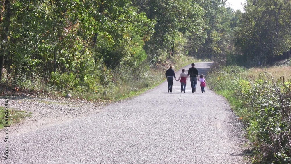 Happy family walking on the rural road.
Happy family walking on the rural road.