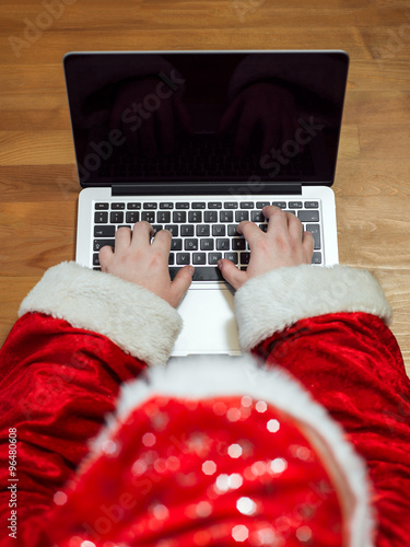 Santa Claus typing on an laptop
