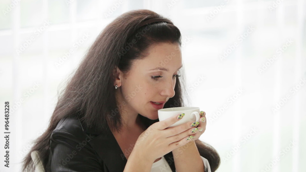 Pretty young woman drinking coffee looking at camera and smiling Pretty young woman drinking coffee looking at camera and smiling