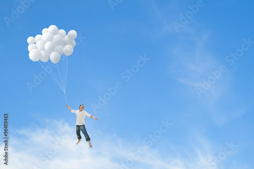 Man lifted into sky by huge bunch of white balloons