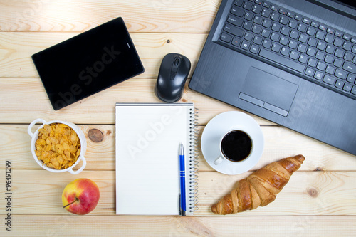 Śniadanie i laptop na drewnianym stole