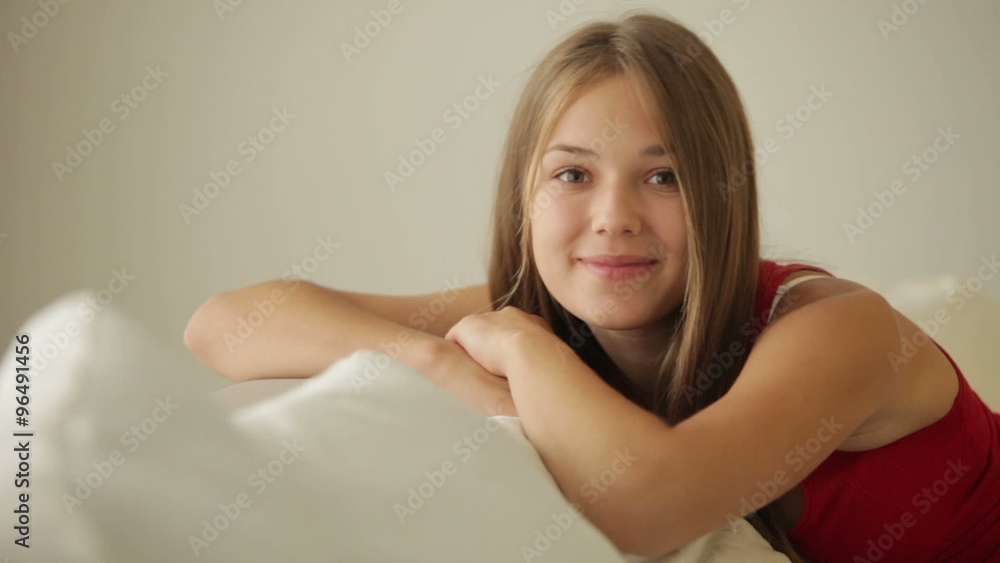 Beautiful girl relaxing on couch smiling at camera Beautiful girl relaxing on couch smiling at camera