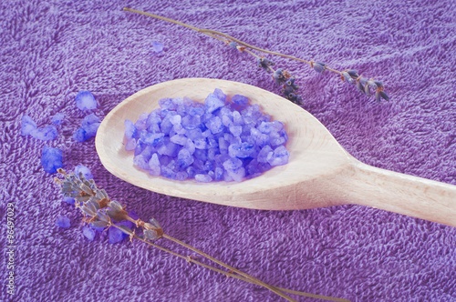 Lavender scented purple bath salt in a wooden spoon