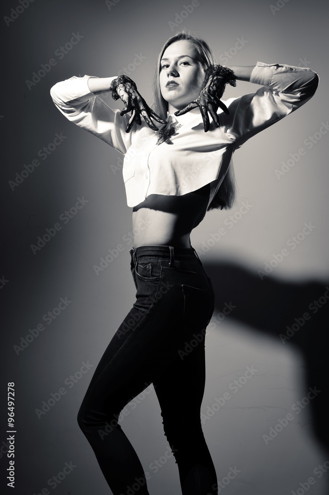 Black and white photography of blonde female in transparent gloves posing in jeans Black and white photography of blonde female in transparent gloves posing in jeans