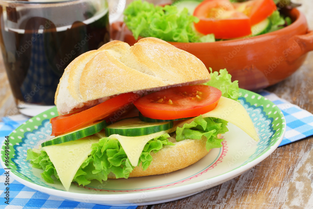 Bread roll with cheese, tomato, cucumber and lettuce, closeup