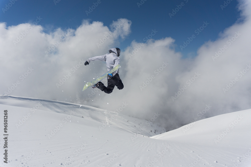 Flying snowboarder on mountains. Extreme sport