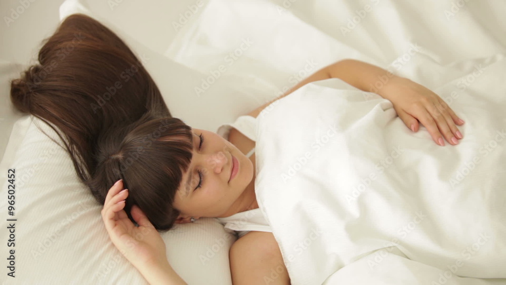 Pretty girl sleeping in bed and smiling in her sleep Pretty girl sleeping in bed and smiling in her sleep