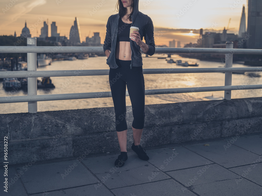 Athletic young woman with cup in London at sunrise