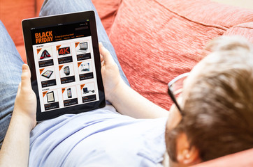 hipster on the sofa with black friday tablet