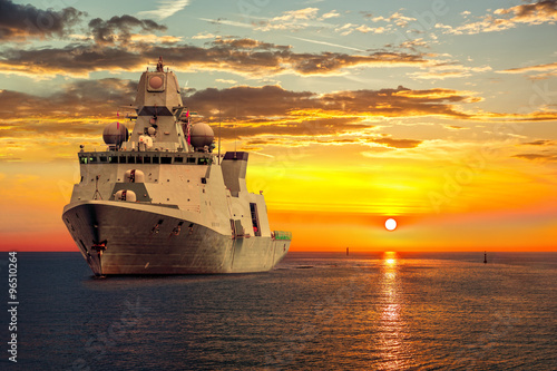 Obraz na płótnie The military ship on sea at sunrise. w salonie