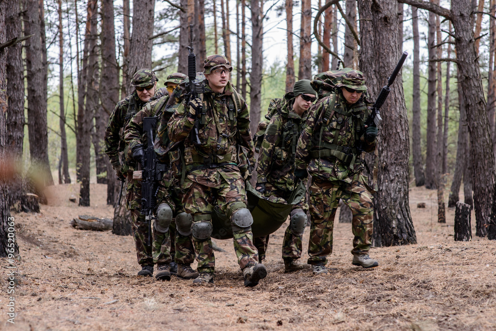 Team of soldiers evacuate soldier on a stretcher Team of soldiers evacuate soldier on a stretcher
