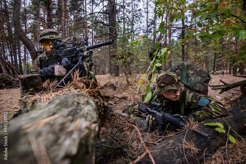 Two soldiers hiding in the woods waiting for attack