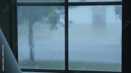 Rain water hitting house windows during thunderstorm