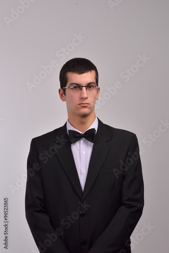 Profile portrait of a fashion young man with glasses in black su
