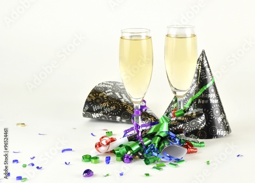 closeup of two Champagne glasses surrounded by New year decoration on light background