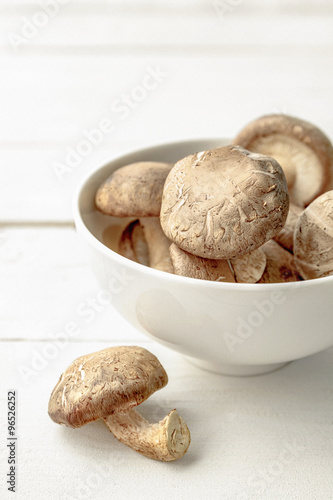 Mushrooms in a ceramic bowl on wood table, Still life with mushr