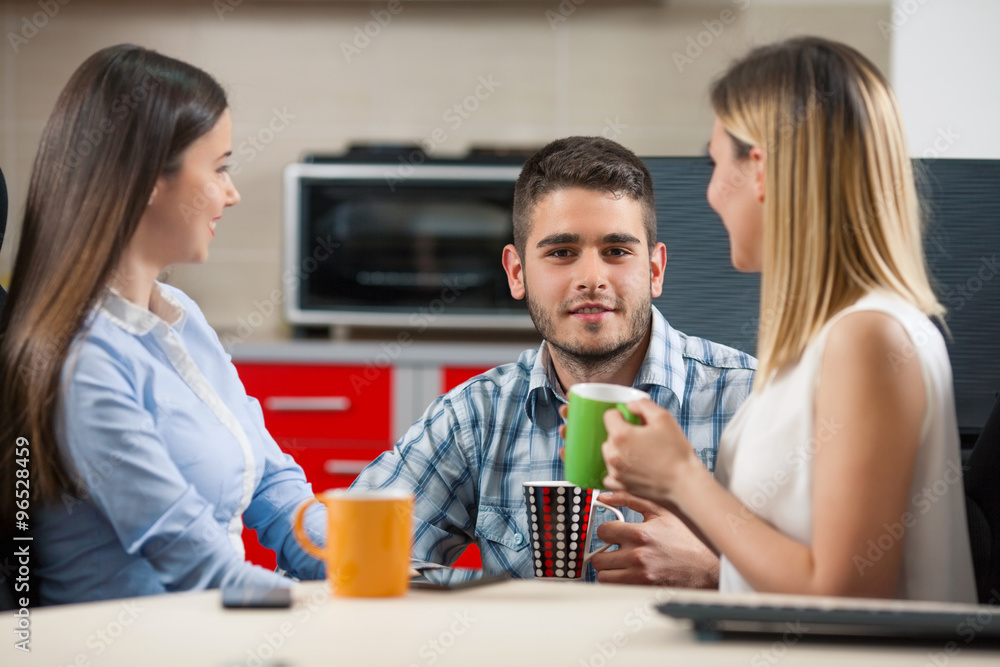 Three young businesspeople having a coffee break in an office Three young businesspeople having a coffee break in an office