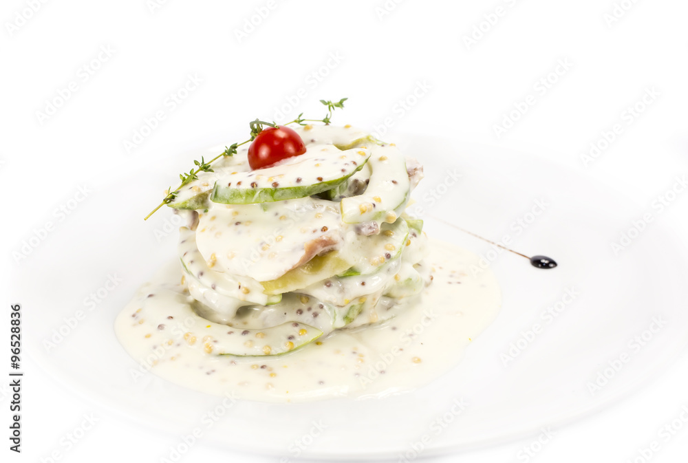 Herring salad with avocado sauce on a plate in a restaurant Herring salad with avocado sauce on a plate in a restaurant