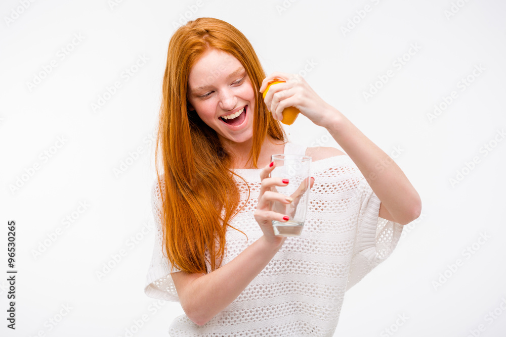 Excited woman squeezing orange juice into a glass by hand Excited woman squeezing orange juice into a glass by hand