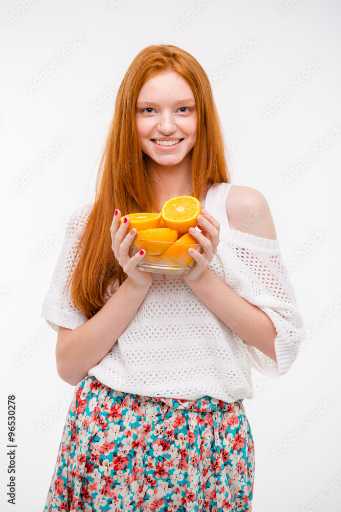 Happy cheerful young female holding oranges in glass bowl Happy cheerful young female holding oranges in glass bowl