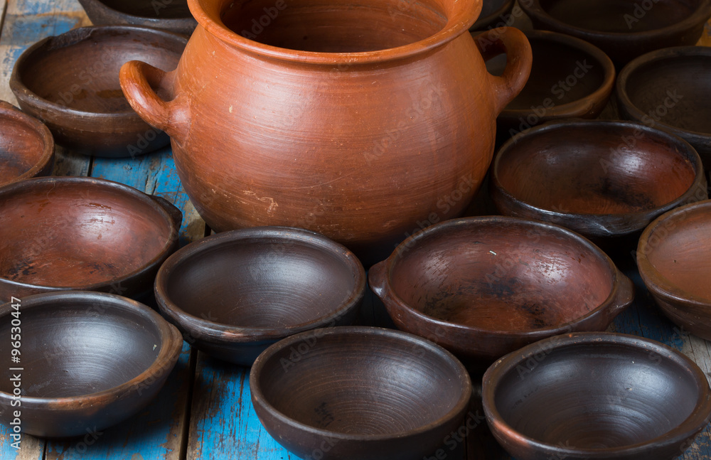Background. Clay pot and dishes on old wooden table