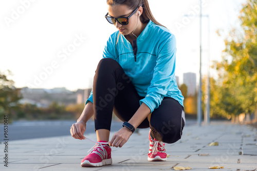 Fototapeta Naklejka Na Ścianę i Meble -  Female athlete tying laces for jogging.