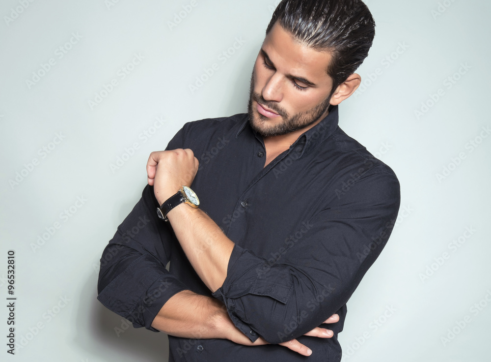 handsome young man in black dress shirt wearing a wristwatch handsome young man in black dress shirt wearing a wristwatch