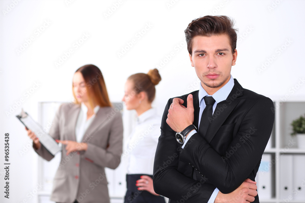 Cheerful business man in office with colleagues in the background, sturt up team Cheerful business man in office with colleagues in the background, sturt up team