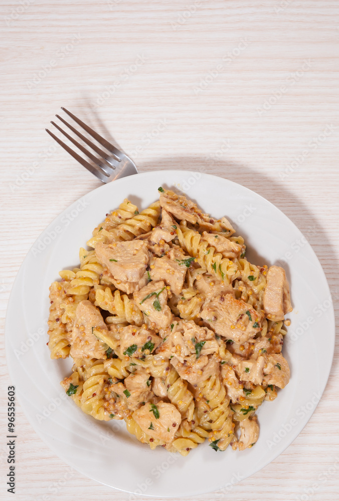 Sliced fried chicken fillet in a creamy and mustard sauce. with fusilli pasta Sliced fried chicken fillet in a creamy and mustard sauce. with fusilli pasta