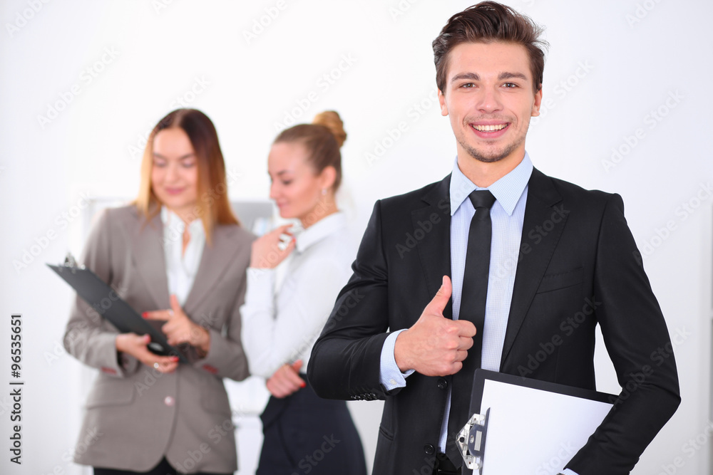 Cheerful business man in office with colleagues in the background, sturt up team Cheerful business man in office with colleagues in the background, sturt up team