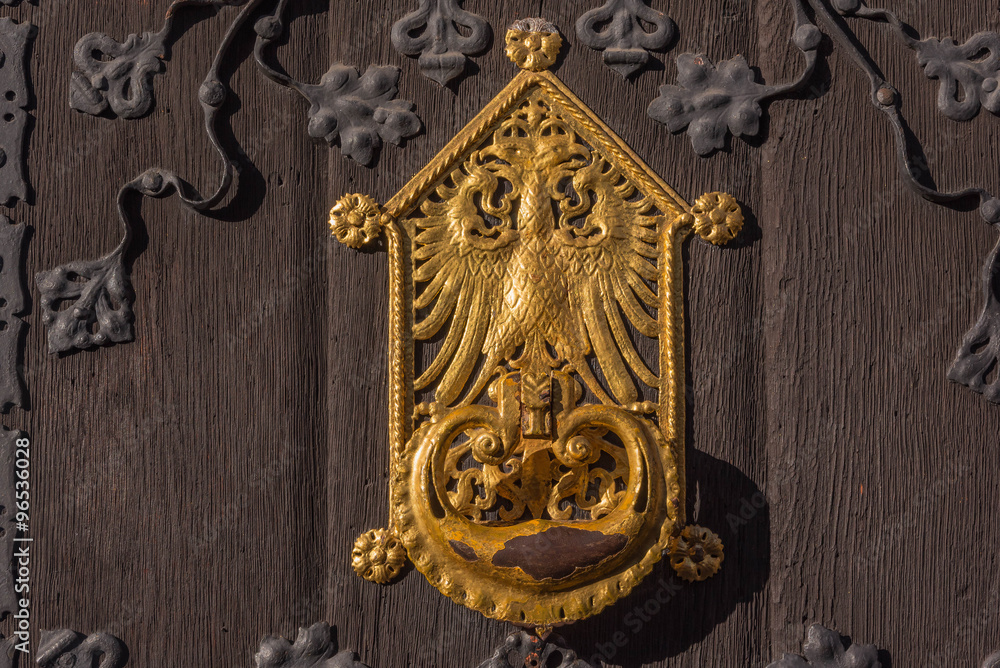 Goldenes Wappen auf Holztüre