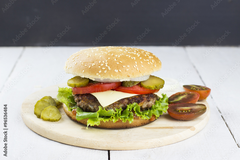 Burger - meat, tomato, gherkin, lettuce, onions on a roll with s