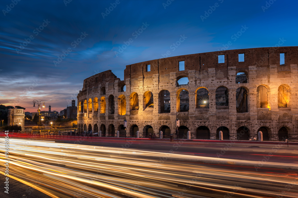 Light trails pass the Colosseum in Rome at dusk
