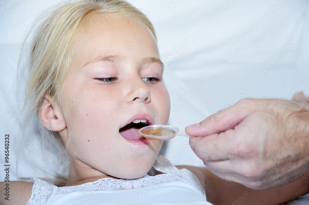 Doctor giving a spoon of syrup  girl