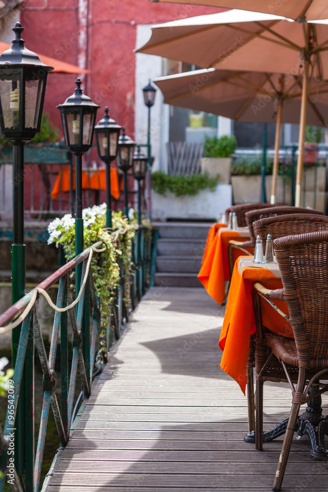 Fototapeta premium Small cafe with wicker furniture and umbrellas on a bridge