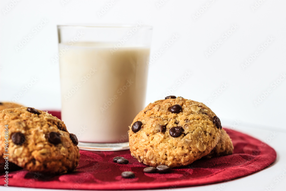 Chocolate chip cookies and milk on a red tablecloth Chocolate chip cookies and milk on a red tablecloth