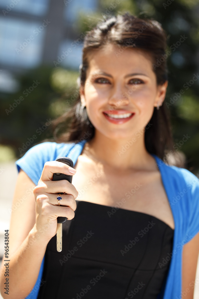 A woman holding up car key. Focus is on key. A woman holding up car key. Focus is on key.